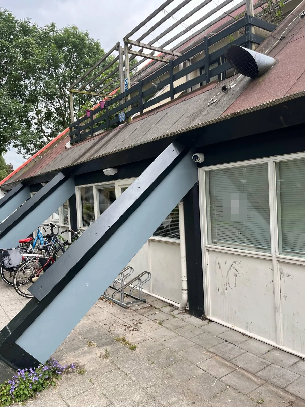 Gevel van het buurtpand met schuine balken en nissen, een witte Dahua-turret onder de dakrand