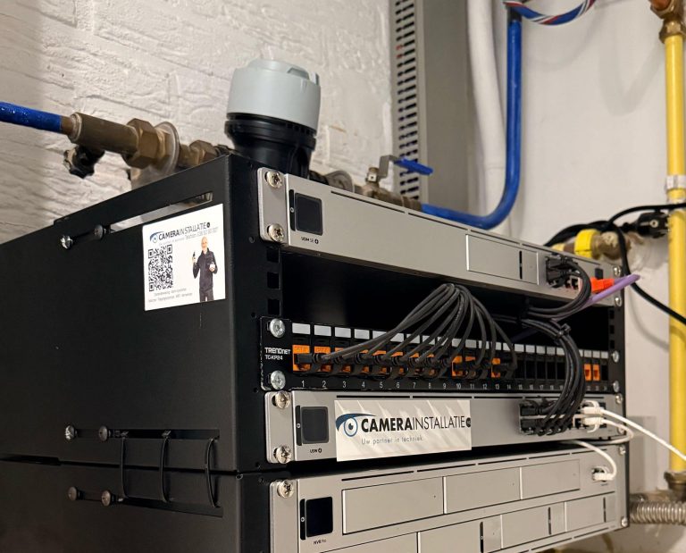 Een klein wandkastje in een woning met recorder, switch en patchpaneel netjes onder elkaar