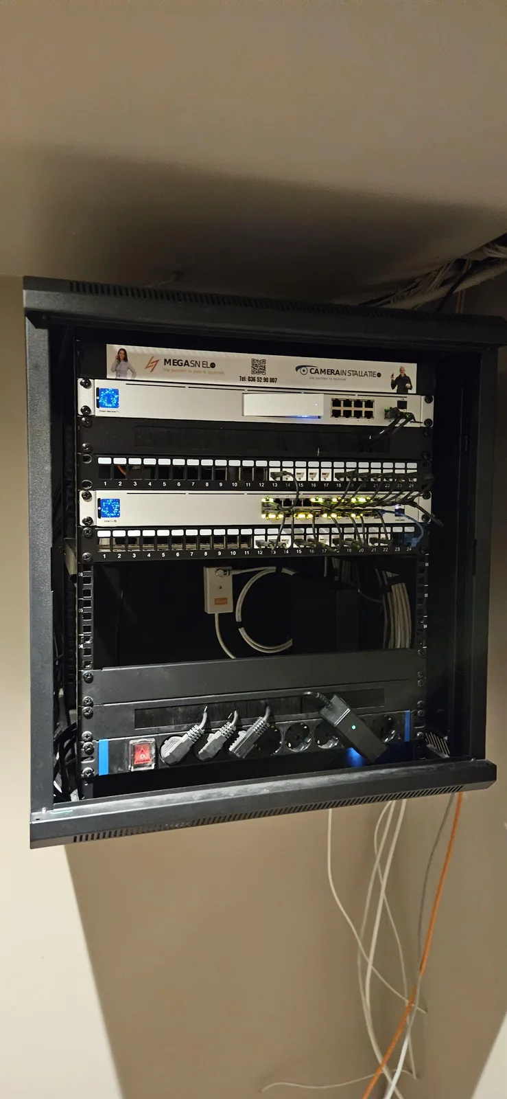 Patchkast met netjes weggewerkte netwerkkabels en een switch, in een woning in Amsterdam
