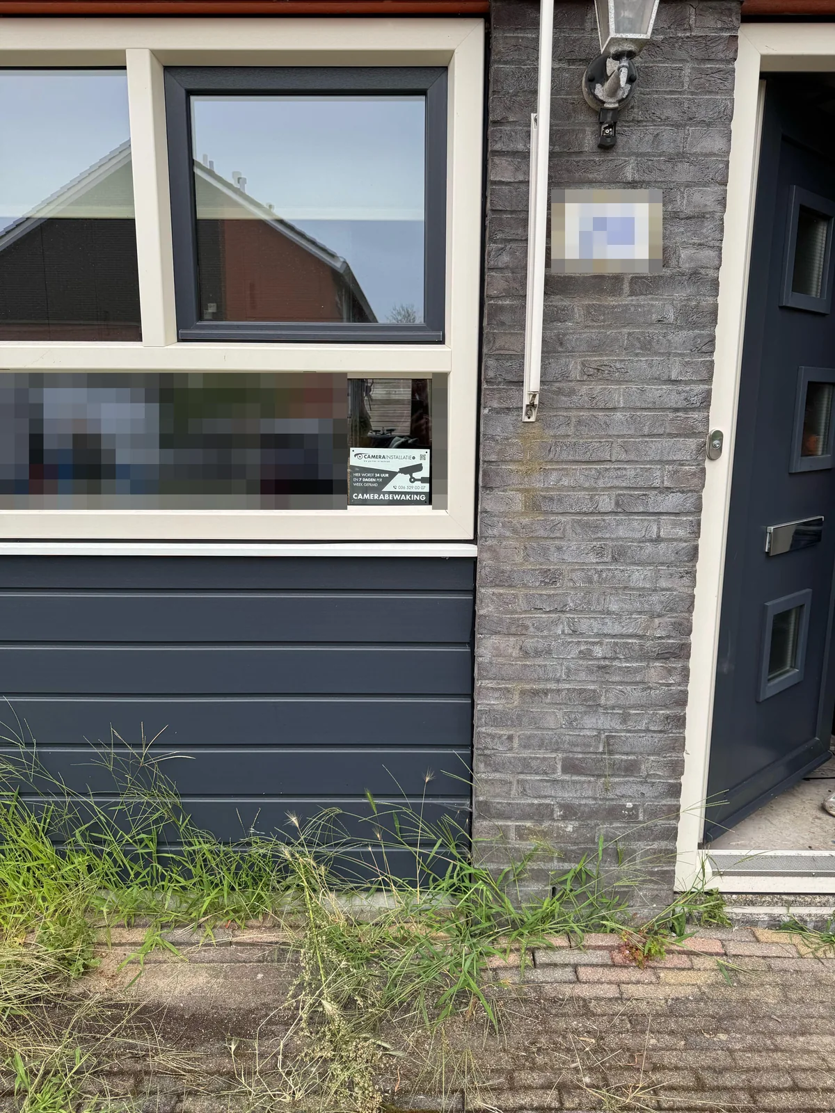 Bordje camerabewaking van CameraInstallatie.nl achter het raam van de voorgevel