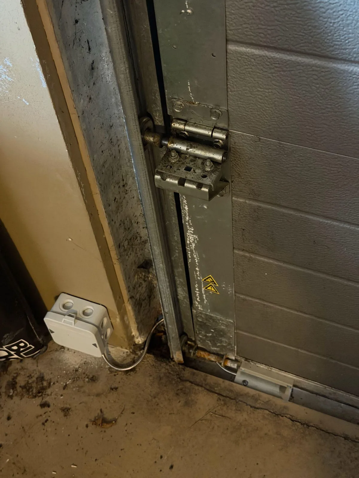 Magneetcontact onder aan de roldeur met een gepantserde kabel naar een lasdoos, in Kropswolde