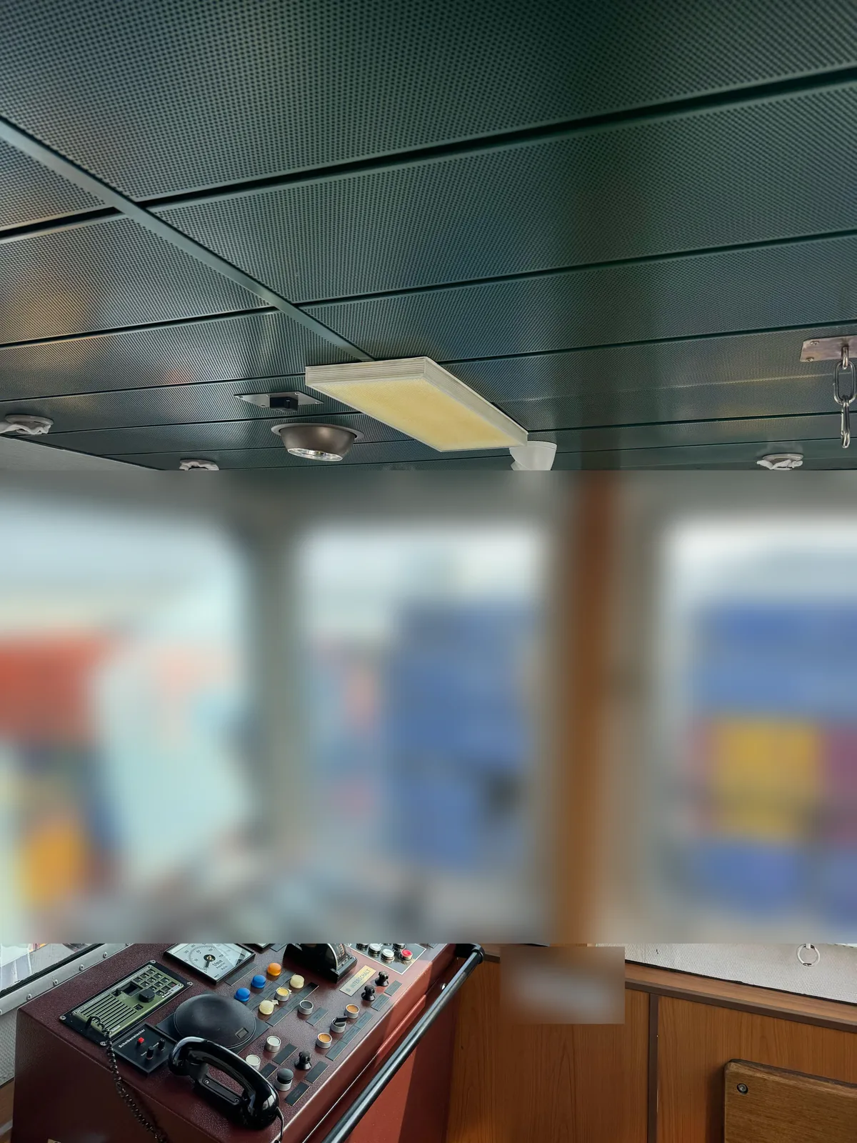 Bedieningspaneel van de stuurhut met daarboven het plafond, de verlichting en een camera