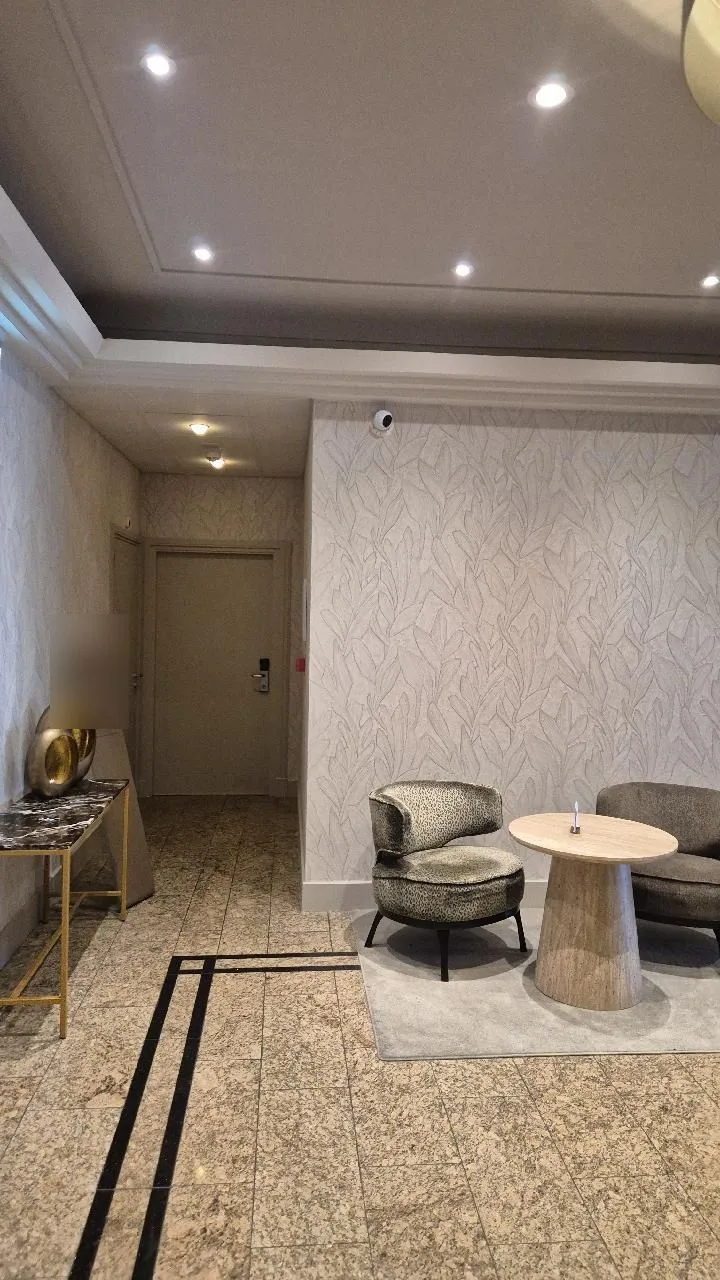 Witte turretcamera aan het plafond van een hotellobby boven een zithoek