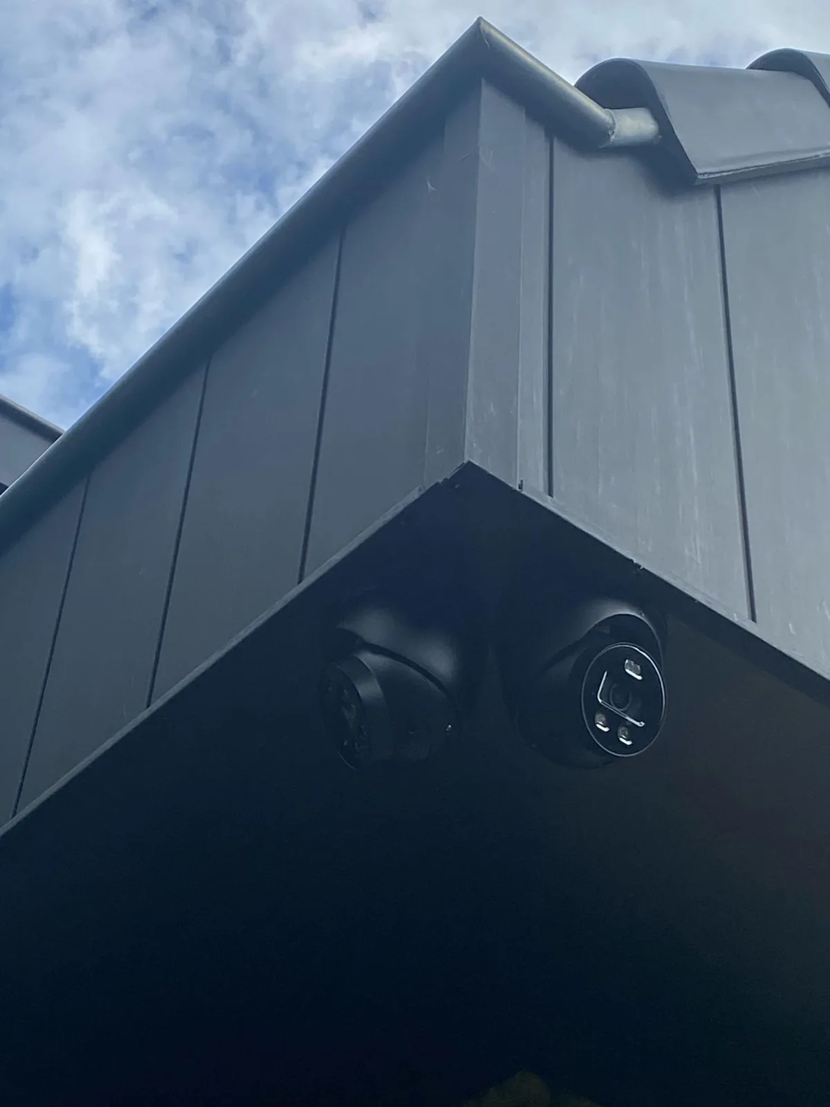 Twee zwarte camera’s op één hoek onder het overstek van een woning in Hilversum