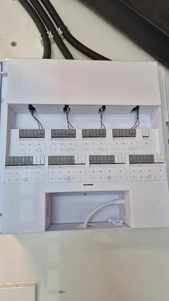 Geopende UniFi Access-hub met acht deurmodules en de deurkabels die van boven binnenkomen