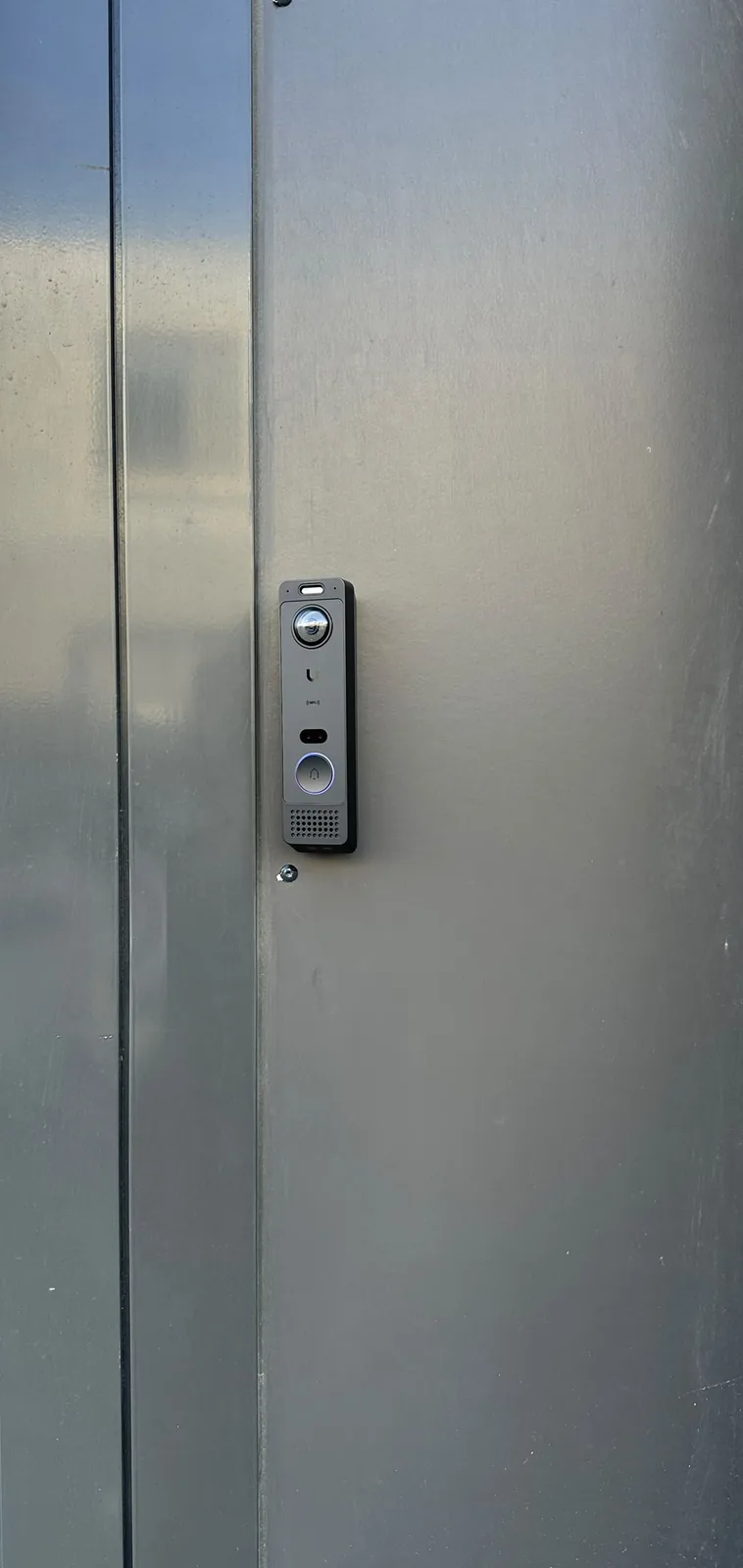 UniFi-deurbel op het aluminium paneel naast de glazen pui van een bedrijfspand