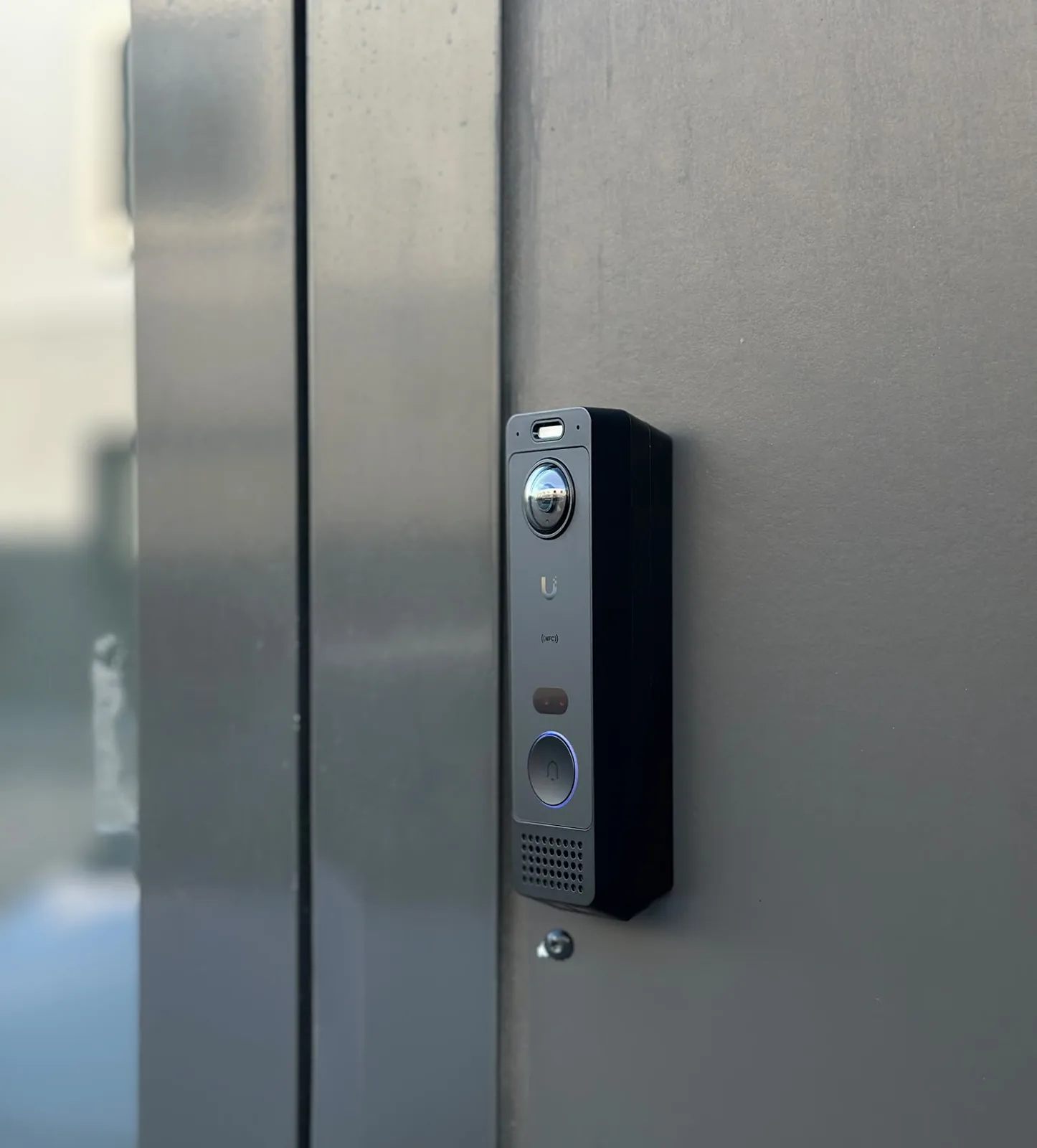 UniFi-deurbel schuin van opzij gezien op een donker aluminium profiel
