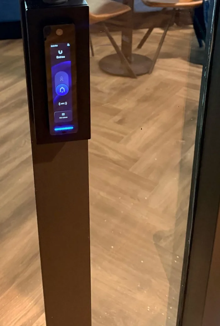 Zwarte UniFi G3 Reader Pro met scherm op het zwarte kozijn van een glazen entreedeur van een kantoor
