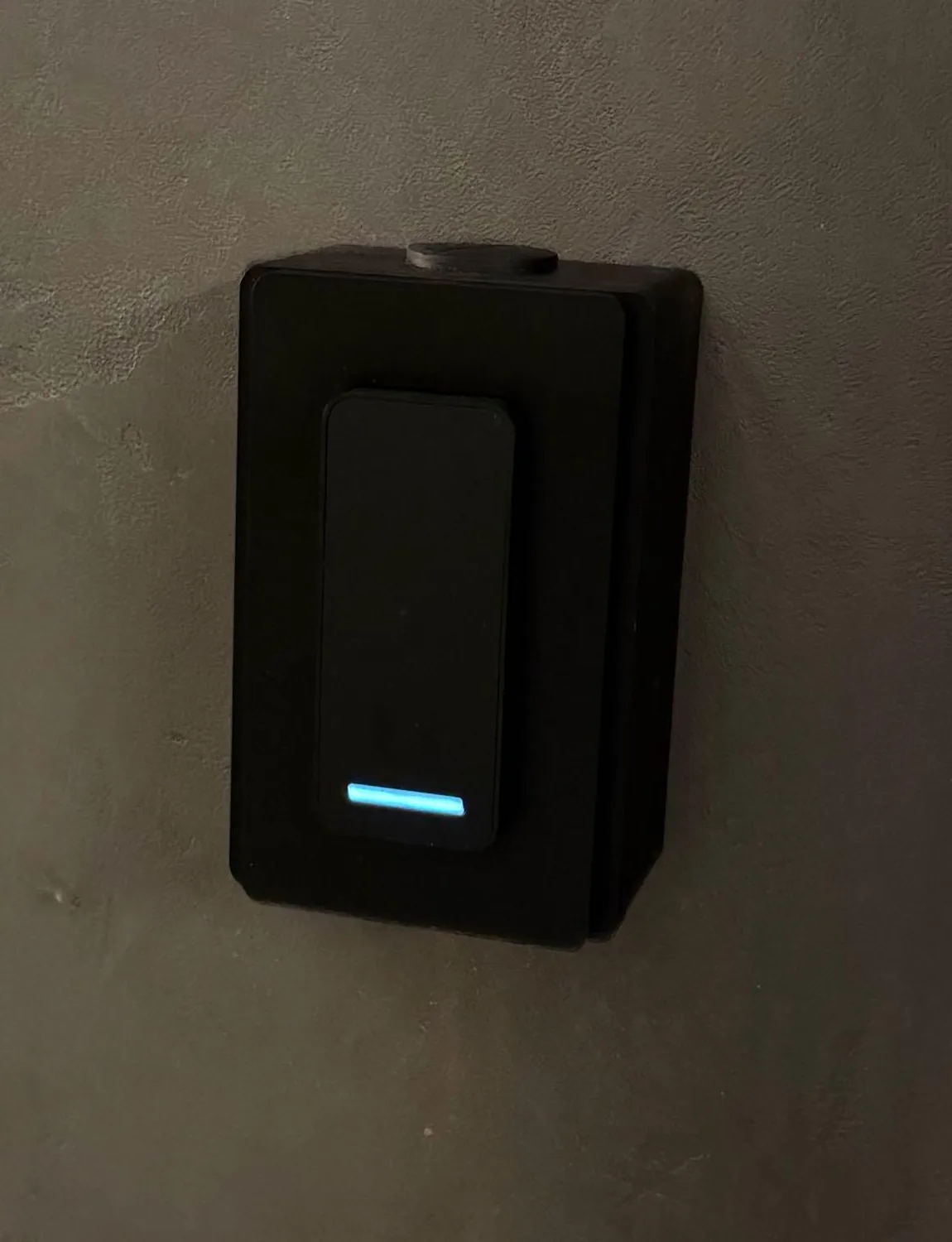Detail van de zwarte UniFi-lezer met blauwe ledstreep op betonlook