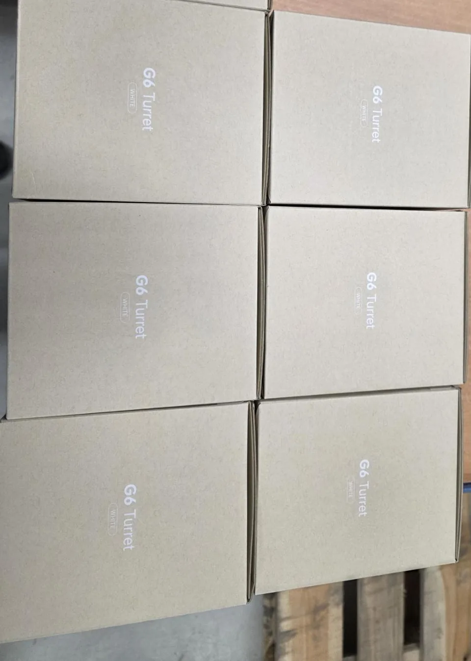 Dozen met witte UniFi G6 Turret-camera's klaargezet op een werkbank