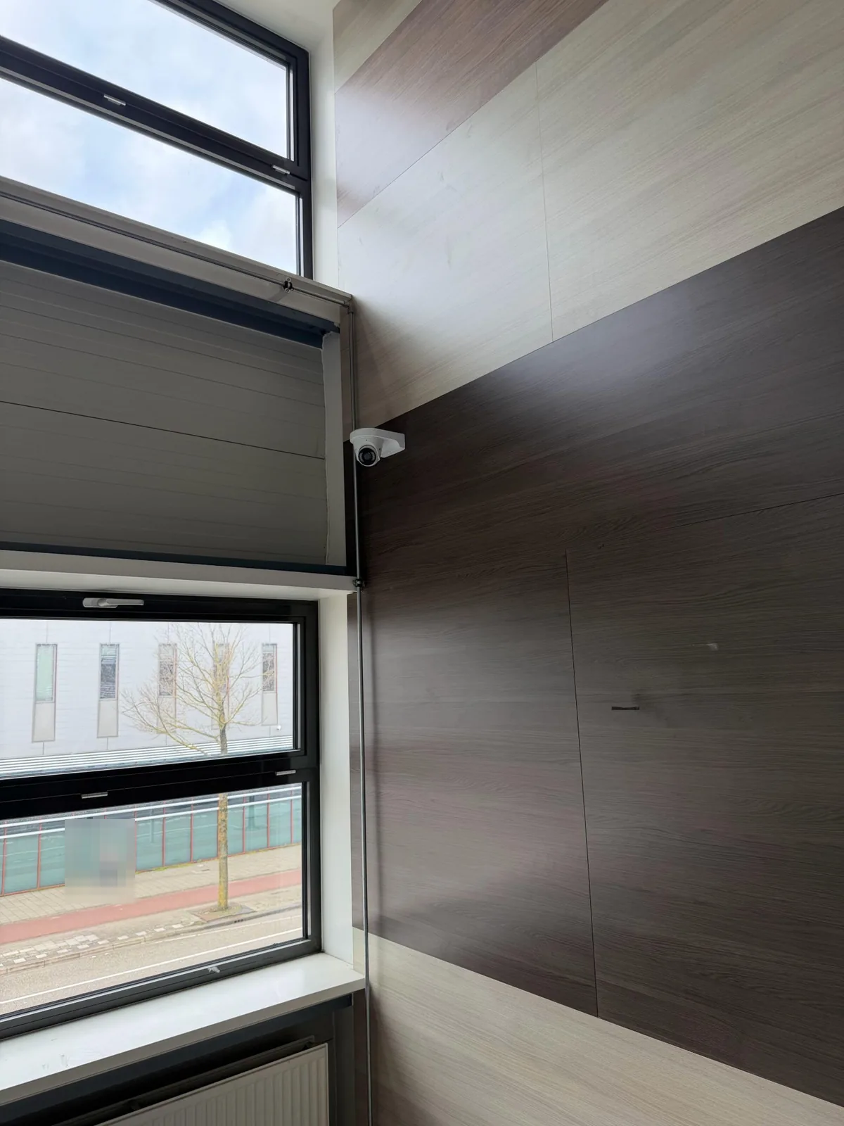 Witte VIGI-turret hoog op een donkere wand naast een raam