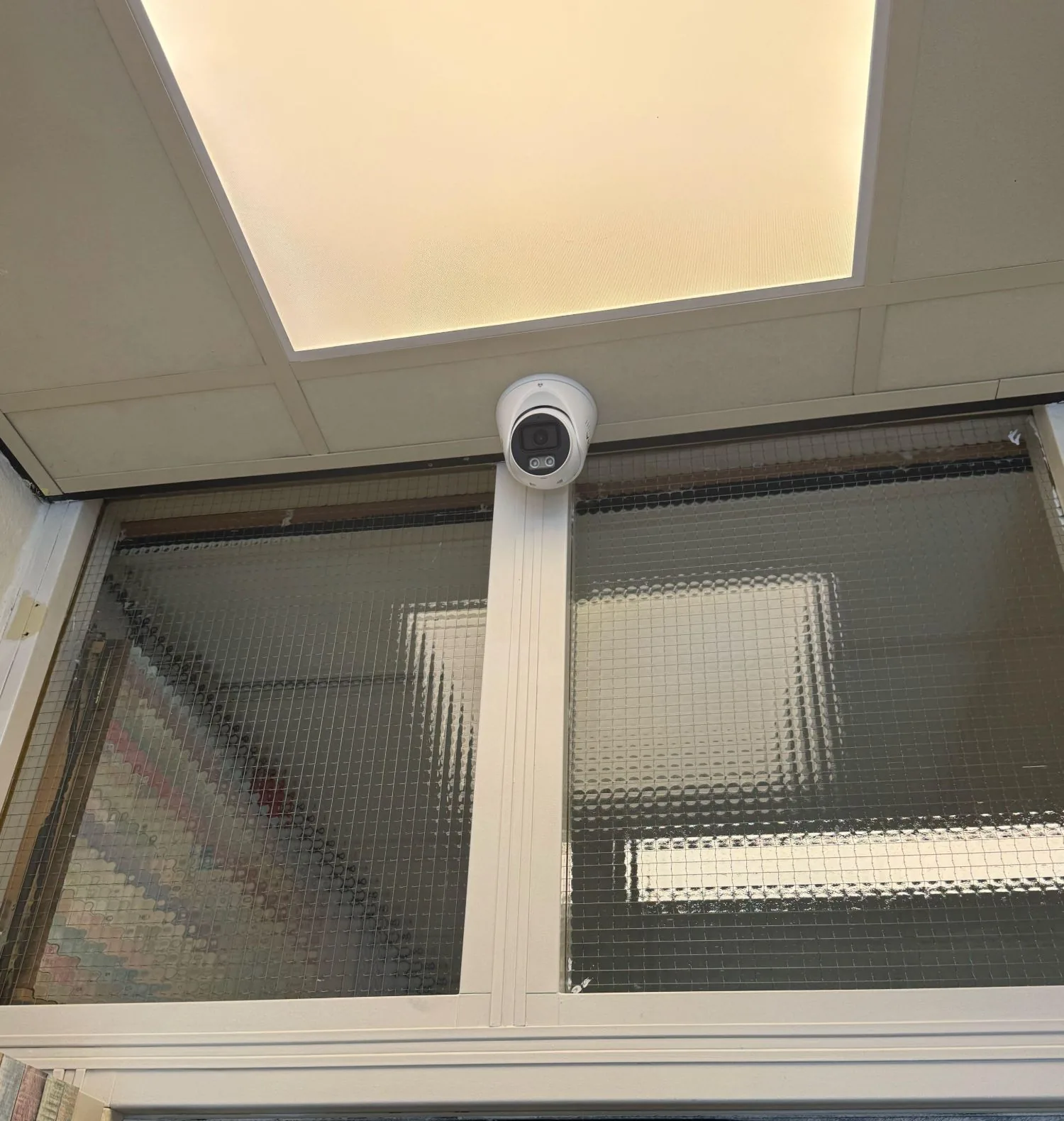 Witte VIGI-turret boven een doorgang met draadglas in een kinderopvang