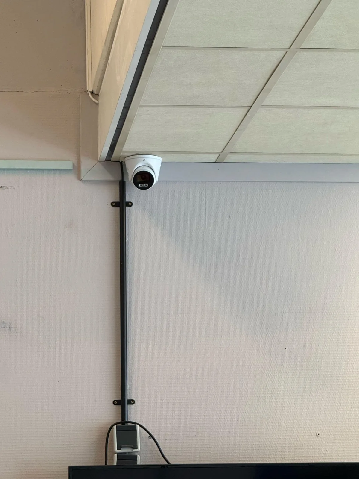 VIGI-turretcamera onder het plafond met de kabel strak in een buis langs de wand naar beneden
