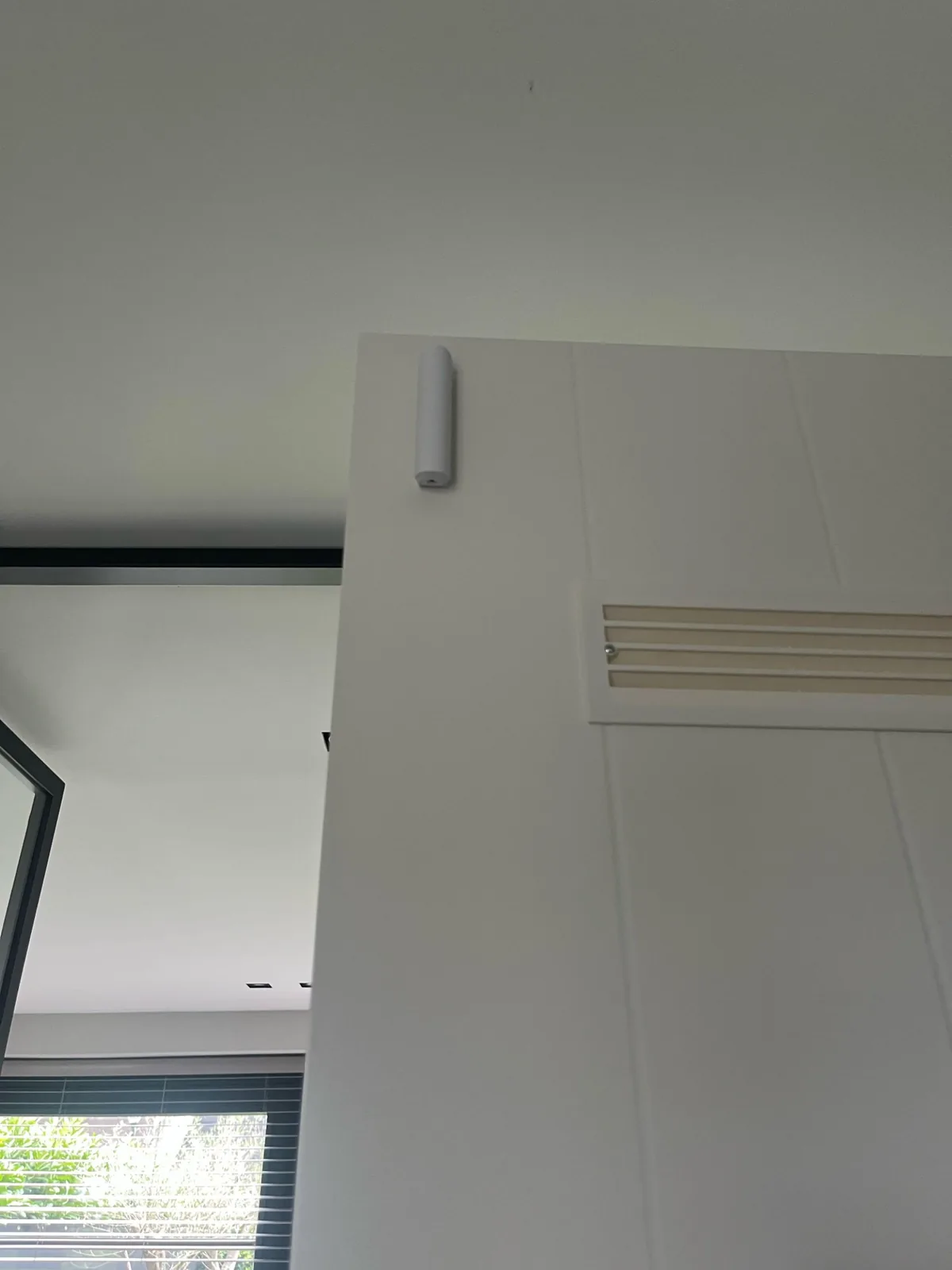 Wit Ajax-contact boven op een witte deur, bij een woning in Blaricum