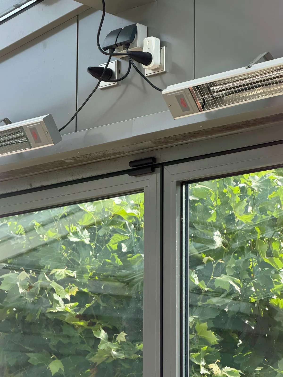 Zwart Ajax Superior DoorProtect-contact boven op glazen schuifdeuren, onder twee terrasstralers
