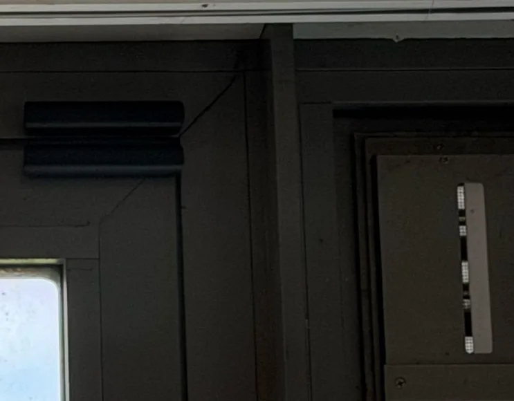 Zwart Ajax Superior-contact, gelijmd boven in een zwart raamkozijn, bij een woning in Kropswolde